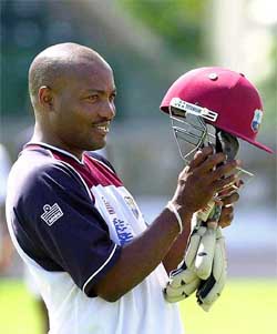 West Indies batsman Brian Lara prepares to put his helmet on during a team practice session