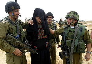 A suspected Palestinian militant dressed as a woman is captured by Israeli soldiers