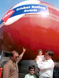 Former ace cricketer Sunil Gavaskar shows a jumbo cricket ball to a young child, which is kept at Marine Drive in Mumbai