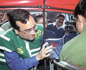 Delhi Minister of Transport and Power Ajay Maken checking the electronic meter in an autorickshaw
