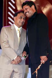 Former Indian all-rounder Kapil Dev poses with former Indian batting legend Sunil Gavaskar after receiving the International Player of the Century award 