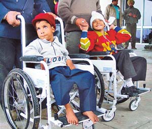 Physically challenged children wait for the Punjab Chief Minister to arrive and offer them wheelchairs at a function 