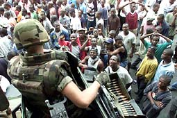 A French soldier mans a machine gun on top of an armoured personnel carrier as angry protesters demonstrate near the departure hall of  Abidjan international airport, Ivory Coast