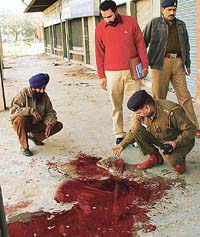 A police official examines the site where 45-year-old night watchman Sohan Singh was clubbed to death in the Sector 34 market in Chandigarh on Wednesday.