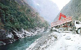 A truck of the Larji Power Project throws muck into the Beas at Dwada, about 35 km from Mandi