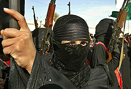 An Iraqi woman holds an Ak-47 rifle during a military march