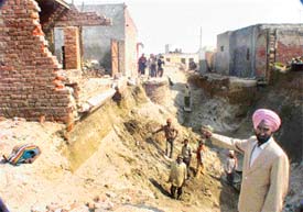 Mohinder Singh, a resident of Chuhar Pur village, shows a portion his house that collapsed due to digging 