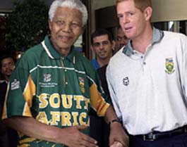 Former South African president Nelson Mandela (L), wearing a cricket jersey, meets South African captain Shaun Pollock