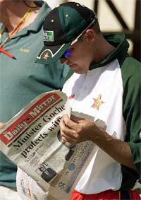 Zimbabwe cricketer Andy Flower reads a copy of a local newspaper 