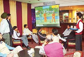 Even the waiter�s eyes are on the giant screen: Guests enjoy food and cricket at Hotel Sunbeam, Sector 22
