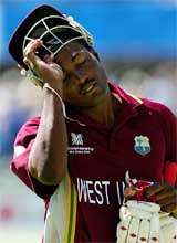 Brian Lara removes his helmet as he walks off the pitch 