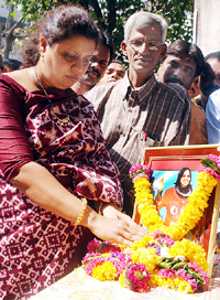 Shiv Sena activists put garlands around a photo