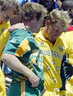 Australia's Shane Warne puts his arm around South Africa's Jonty Rhodes during an official photo session aboard a navy ship