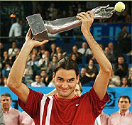 Roger Federer of Switzerland raises his trophy after defeating Jonas Bjorkman of Sweden