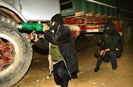 A Palestinian fighter carries a makeshift anti-tank rocket 