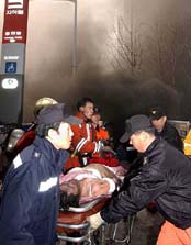South Korean rescue workers remove a victim from a fire on a subway line 