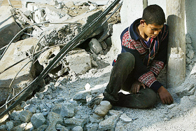 A boy sits on the remains of his home which was destroyed by Israeli troops in Tufah
