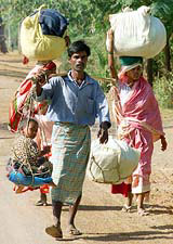 A tribal man carries his child in a bamboo basket