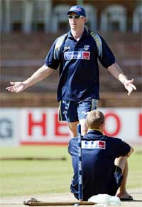 Australia�s Glenn McGrath gestures as team-mate Mathew Hayden sits in front of a stump at Queens Sports Club in Bulawayo