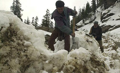 Labourers clears the snow from a road