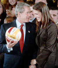 US President Bush holds a volleyball presented to him by Lauren Killian
