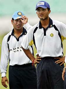 Captain Saurav Ganguly and Sachin Tendulkar look at teammates train during a practice session