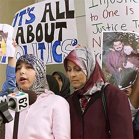Leena (L), daughter of arrested Prof Sami Al-Arian, reads a statement for her father as her mother, Nahla (R), looks on at the Federal Court House in Tampa, Florida