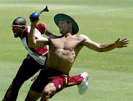 West Indies' Ricardo Powell is chased by team mate Vasbert Drakes during a practice session 