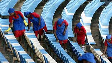 South African grounds staff wipe the seats in Supersport Park