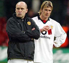 A dejected Manchester United captain David Beckham stands with a club official 