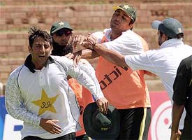 Pakistan cricketers Younis Khan and Inzamam-ul Haq are separated by Saeed Anwar and an unidentified team-mate during a dispute while playing football during a practice session