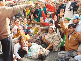 Protesters surround women who were injured when the police resorted to lathi charge and use of water cannon to end a blockade on the Chandigarh-Kalka National Highway
