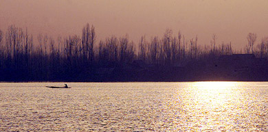 A Kashmiri rows a small boat on Dal Lake