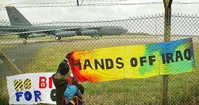 A peace protester places banners on the perimeter fence