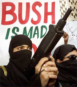 A Pakistani woman brandishes a mock gun during a rally