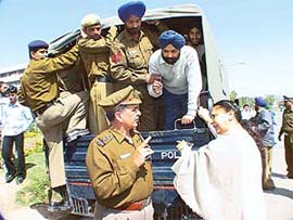 Wife of one of the persons rounded up by the police argues with cops while her husband is being taken to a police station in Chandigarh
