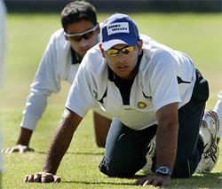 Yuvraj Singh and Mohammad Kaif perform stretching exercises during a practice session 