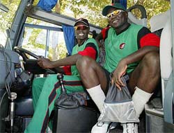 Kenyan captain Steve Tikolo and team mate Tony Suji play with the steering wheel of their team bus 