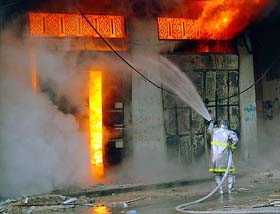 A fireman tries to control a fire in a shop at the Jabalya refugee camp in the northern Gaza Strip 