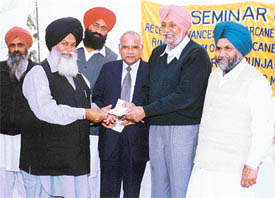 Mr Gurcharan Singh Ghalib, MP, and Mr Malkiat Singh Dakha, MLA, distribute cheques among farmers
