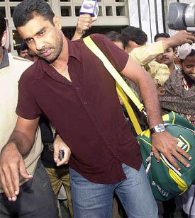 Pakistani cricket captain Waqar Younis tries to avoid the media upon his arrival at Lahore International Airport