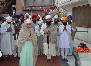 A Sikh woman performs 'ardas' at Akal Takht