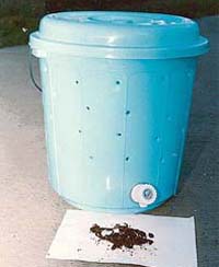 The portable vermi-composting unit showing earthworms in the foreground