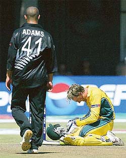 Australia's Andy Bichel sits on the pitch after being hit on the helmet