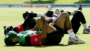 Kenya's Alpesh Vadher protects his face from the sun during a practice session 