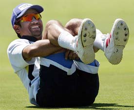 Master batsman Sachin Tendulkar smiles while doing stretching exercises 