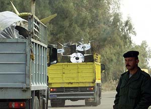 An Iraqi soldier stands next to a truck with parts of banned al-Samoud 2 missiles outside al-Taji base, 40 km north of Baghdad