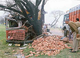 A policeman inspects the spot where a truck rammed into a tree claiming two lives at Ballopur village on the Lalru-Handesra village link road near Lalru on Friday.