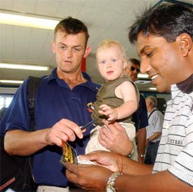 Australian stumper Adam Gilchrist with his son Harrison signs autographs for fans