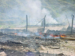 The remains of jhuggies smoulder near Bakarti village in Hamirpur district